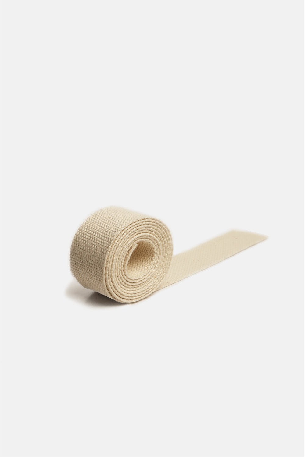 A roll of 1" wide, natural-beige 100% cotton webbing, rolled up on a white background.