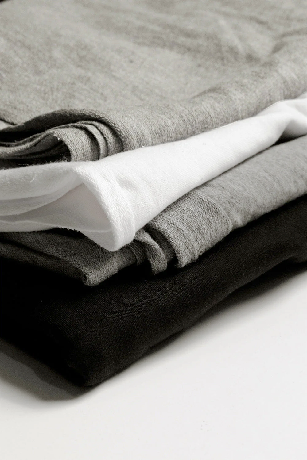 Layered fabrics in black, heather grey, and snow white for the Regular T-Shirt DIY Kit and Pattern