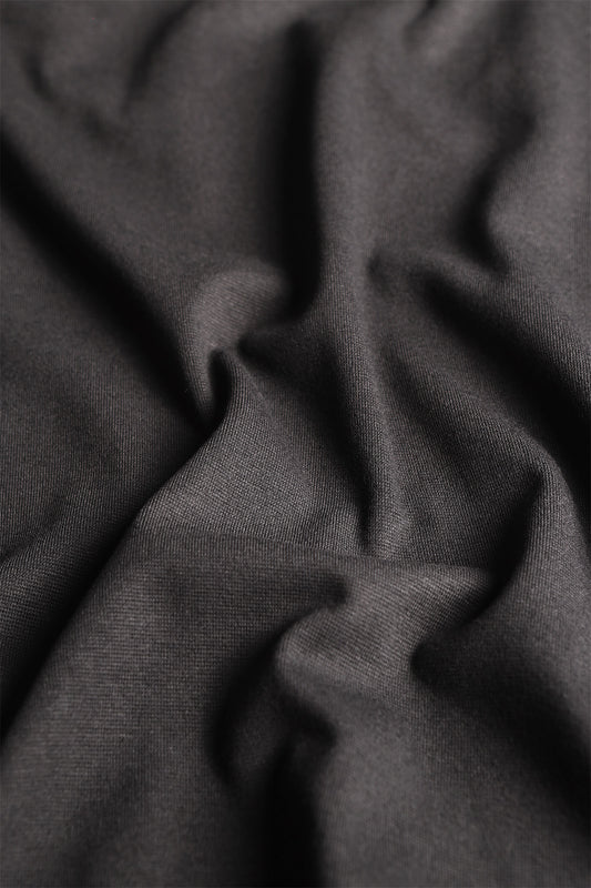 Versatile rib knit textile in true black, ideal for crafting fitted garments and accessories.
